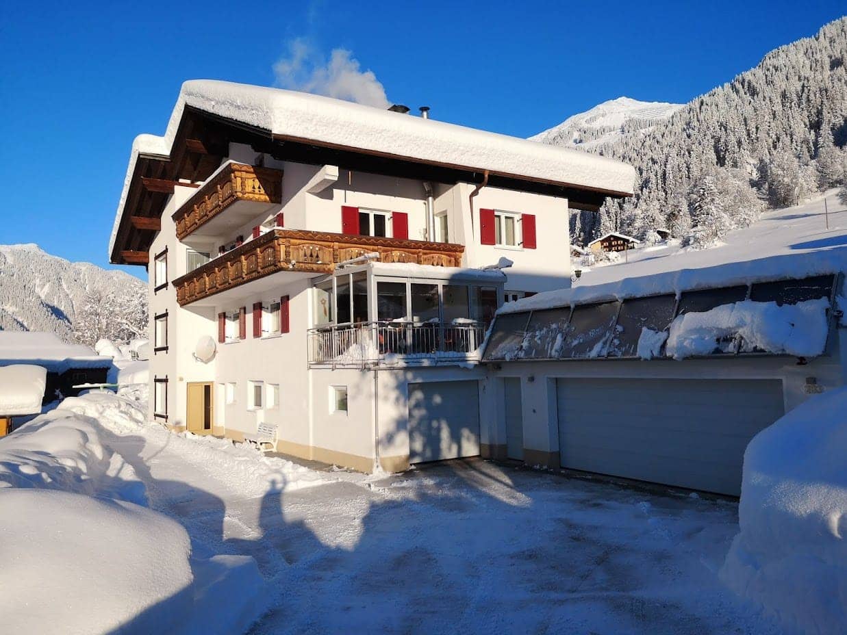 Verschneites Ferienhaus Lerch mit Balkon und Garage im Winter